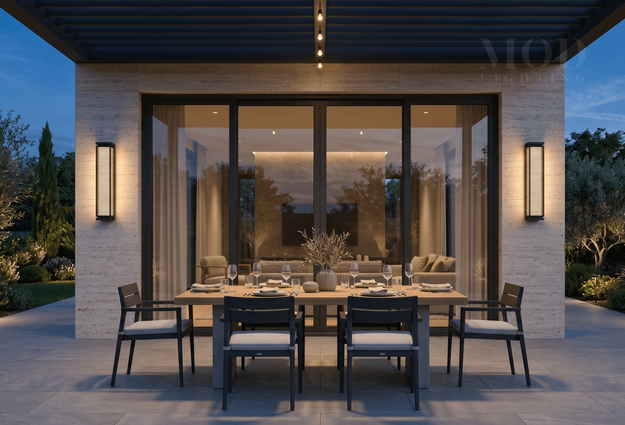 Modern outdoor patio set up for entertaining with layered warm light